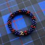 tartan-inspired beaded gemstone bracelet in clan morgan colorway on matching plaid fabric