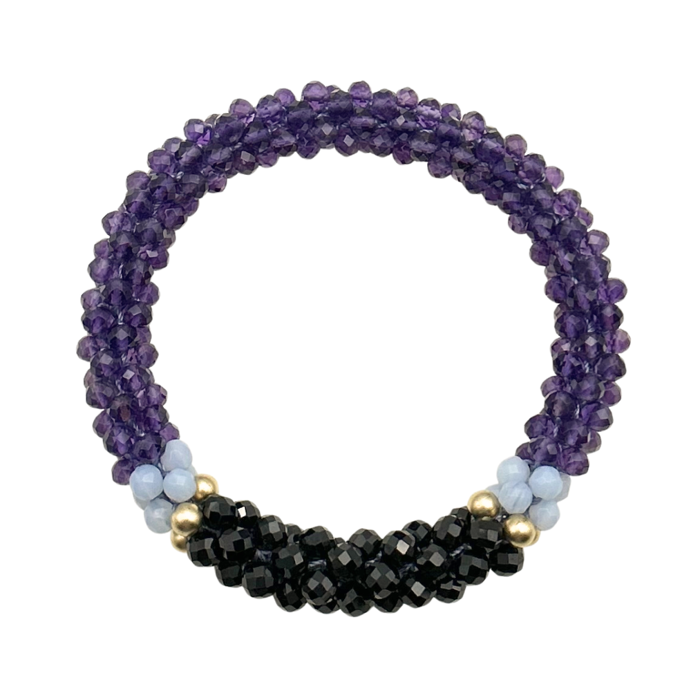 Handmade beaded gemstone bracelet in purple with black accent on a white background