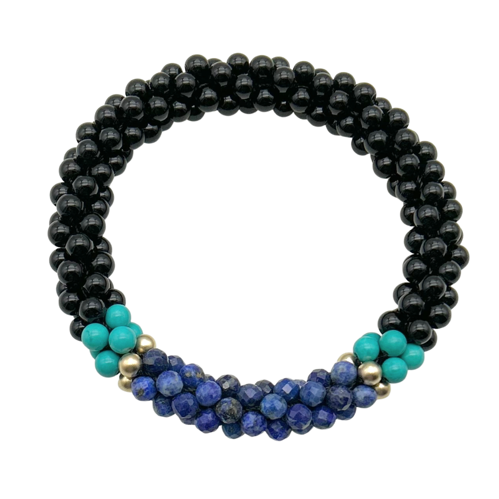 Handmade beaded gemstone bracelet in black with blue accents on a white background