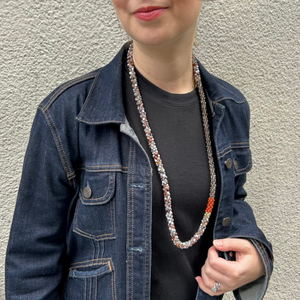 handmade beaded gemstone necklace in brown agate, smoky quartz, orange carnelian and gold on model with jacket