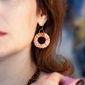 closeup handmade beaded gemstone earring with pink aventurine rings and gold earwires worn on model