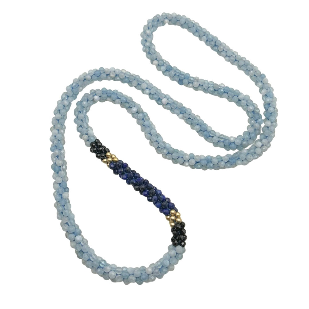 Handmade beaded gemstone necklace in shades of blue with black on a white background