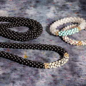 black onyx, dalmatian jasper and gold beaded gemstone necklace with two bracelets