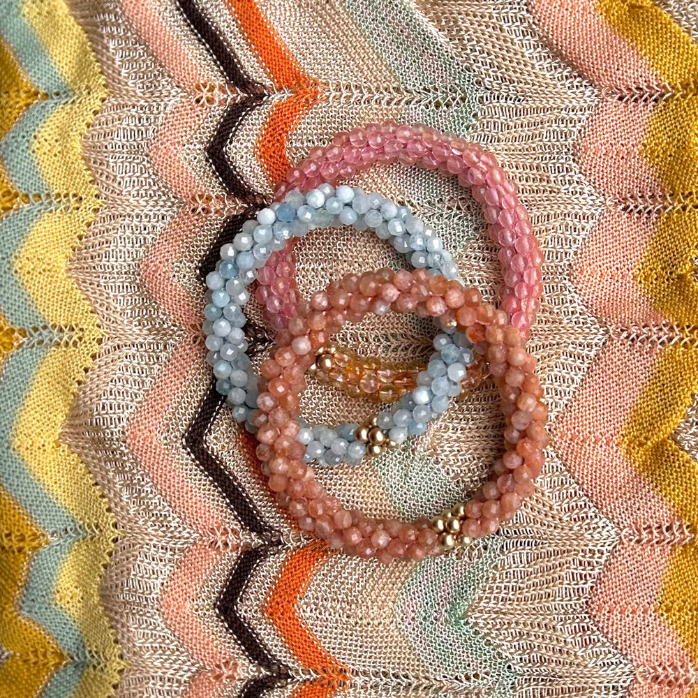 three handmade beaded gemstone bracelets in sunstone, aquamarine and cherry quartz on missoni scarf