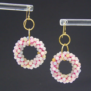 beaded gemstone earrings with small morganite rings, interlocking gold rings and gold earwires on black background