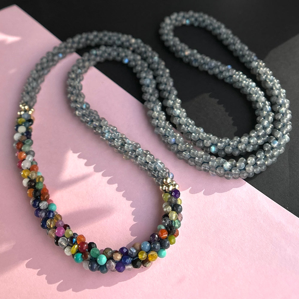 handmade beaded gemstone necklace in grey with multicolor accent on two tone background