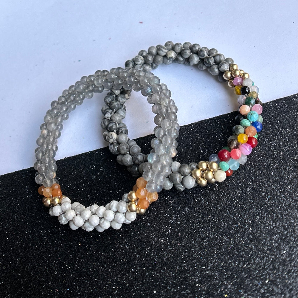 Set of handmade beaded gemstone bracelets in grey and multicolor on a black and white background