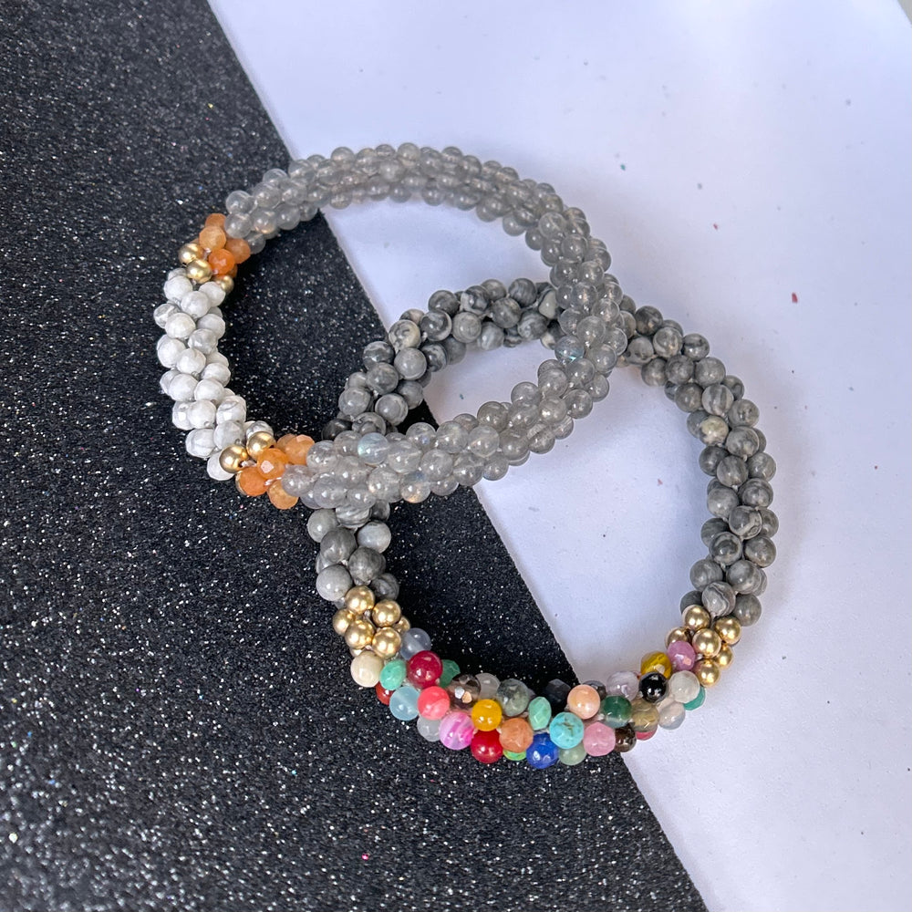 Set of handmade beaded gemstone bracelets in grey and multicolor on a black and white background
