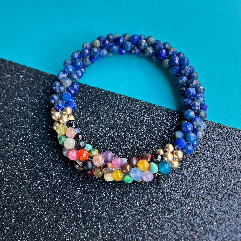 handmade beaded gemstone bracelet in lapis with a multicolor accent on a two tone background