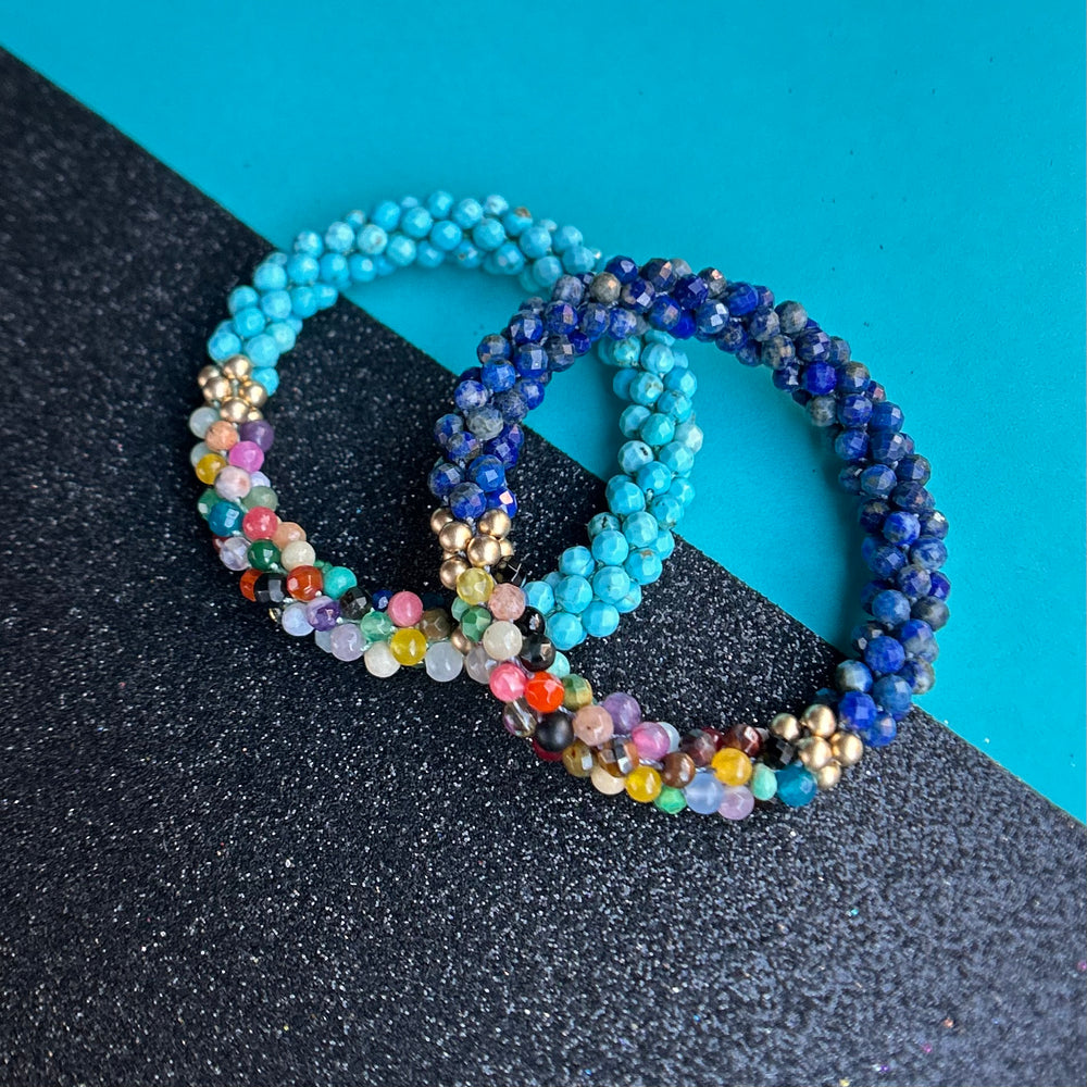 set of handmade beaded gemstone bracelets in blues with multicolor accents on two tone background