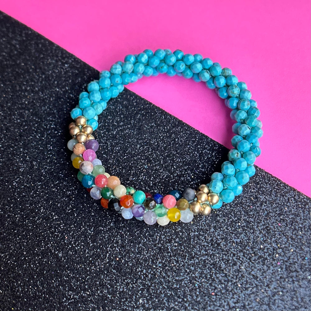 handmade beaded gemstone bracelet in turquoise with a multicolor accent on a two tone background