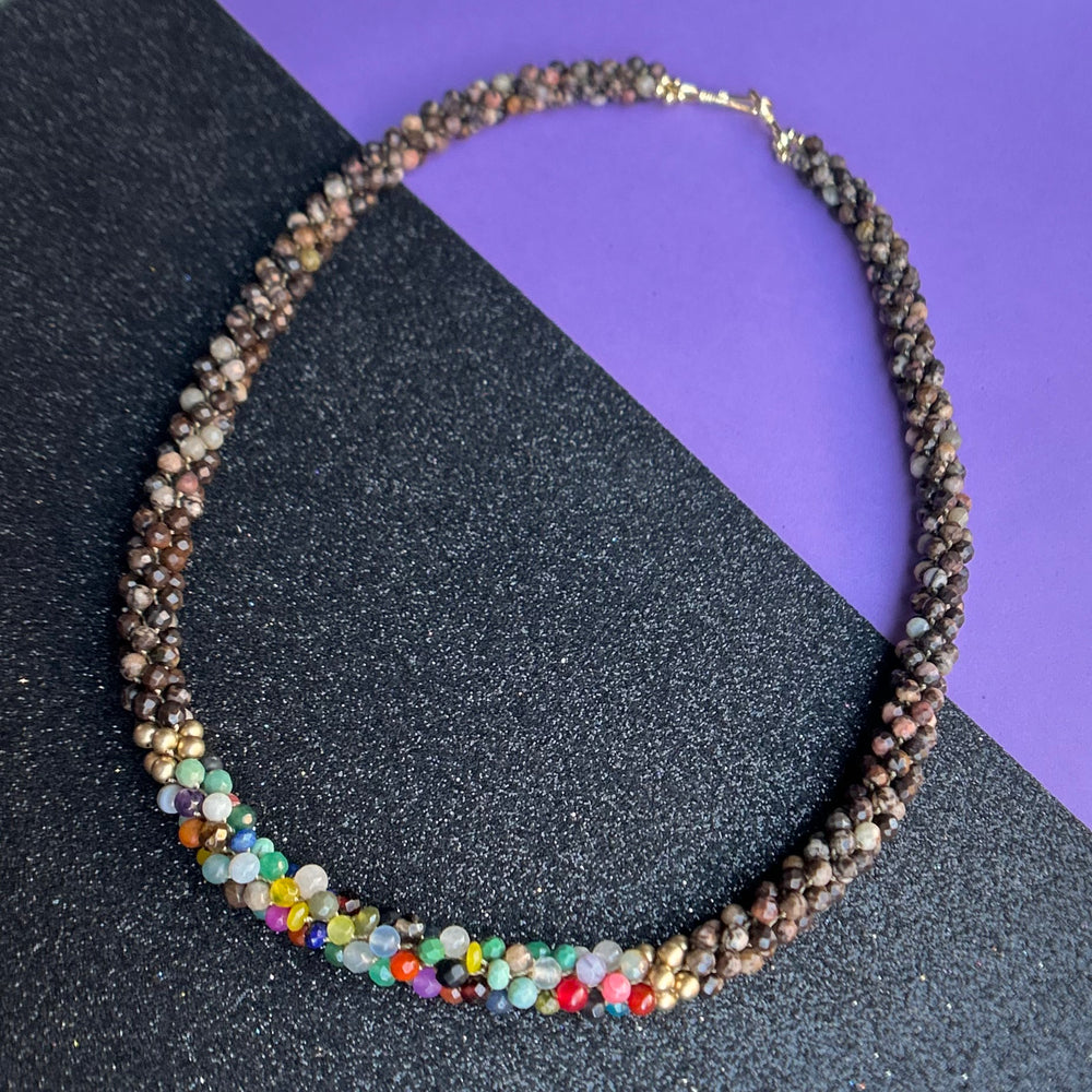 handmade beaded gemstone necklace in brown with multicolor accent and clasp on black and purple background