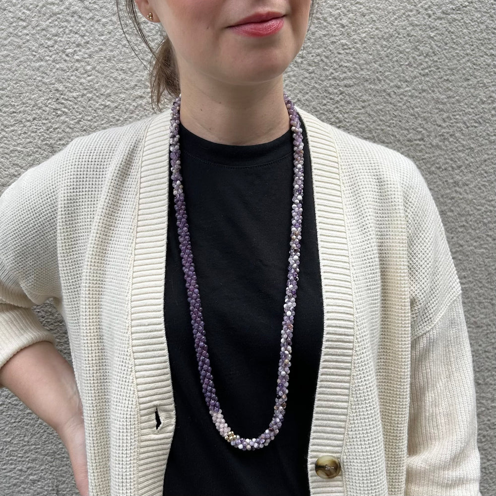 handmade beaded gemstone necklace in purple amethyst and lepidolite, rose quartz and gold accent on model with cream sweater