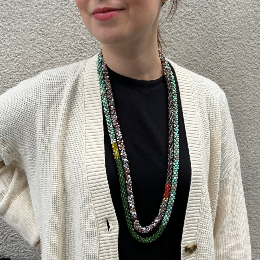 handmade beaded gemstone necklace in brown agate, smoky quartz, orange carnelian and gold on model layered with another necklace