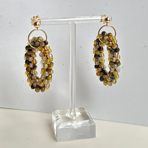 beaded gemstone earrings with large multicolor agate rings and gold ball posts on white background
