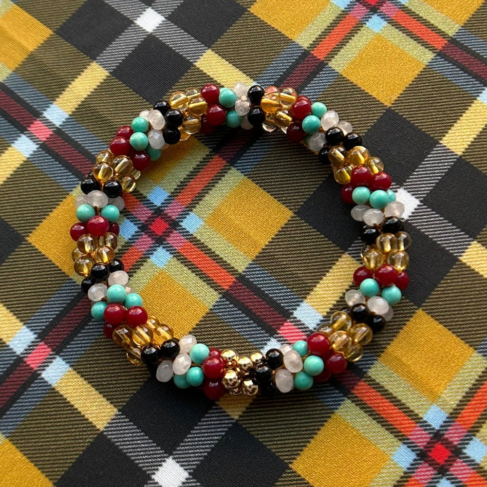 tartan-inspired beaded gemstone bracelet in Cornish national colorway on matching plaid fabric