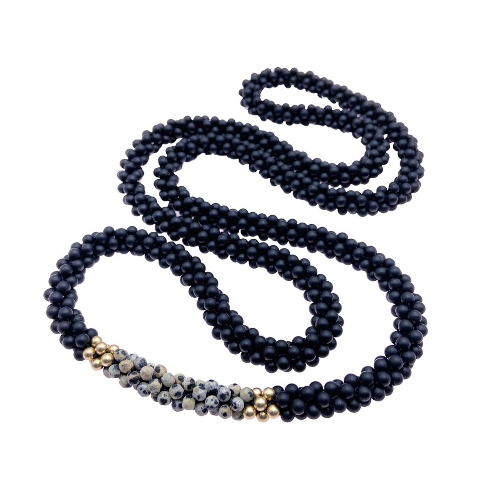 black onyx, dalmatian jasper and gold beaded gemstone necklace on white background