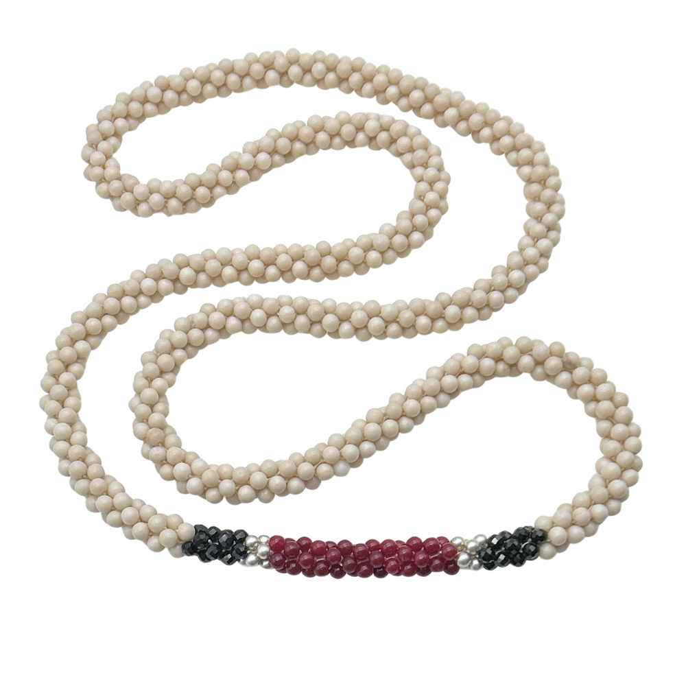 Handmade beaded gemstone necklace in cream, black and red on a white background