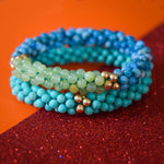 apatite, green calcite and gold beaded bracelet with turquoise bracelet on colorful background