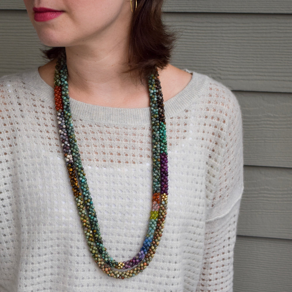 rainbow, african turquoise and gold beaded necklace on model worn with another gemstone necklace