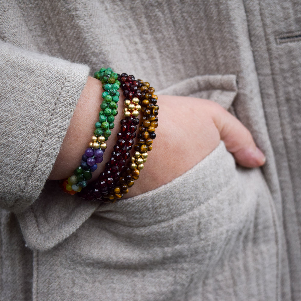 tiger eye and gold beaded gemstone bracelet on model worn with two other bracelets