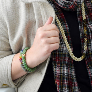 jade and gold beaded bracelet worn on model with another bracelet and a necklace