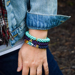 rainbow, lapis and gold beaded bracelet on model worn with two other bracelets