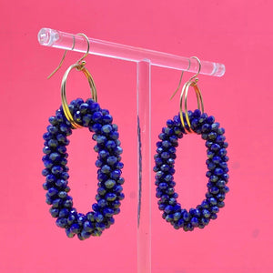 lapis and gold beaded gemstone earrings on pink background
