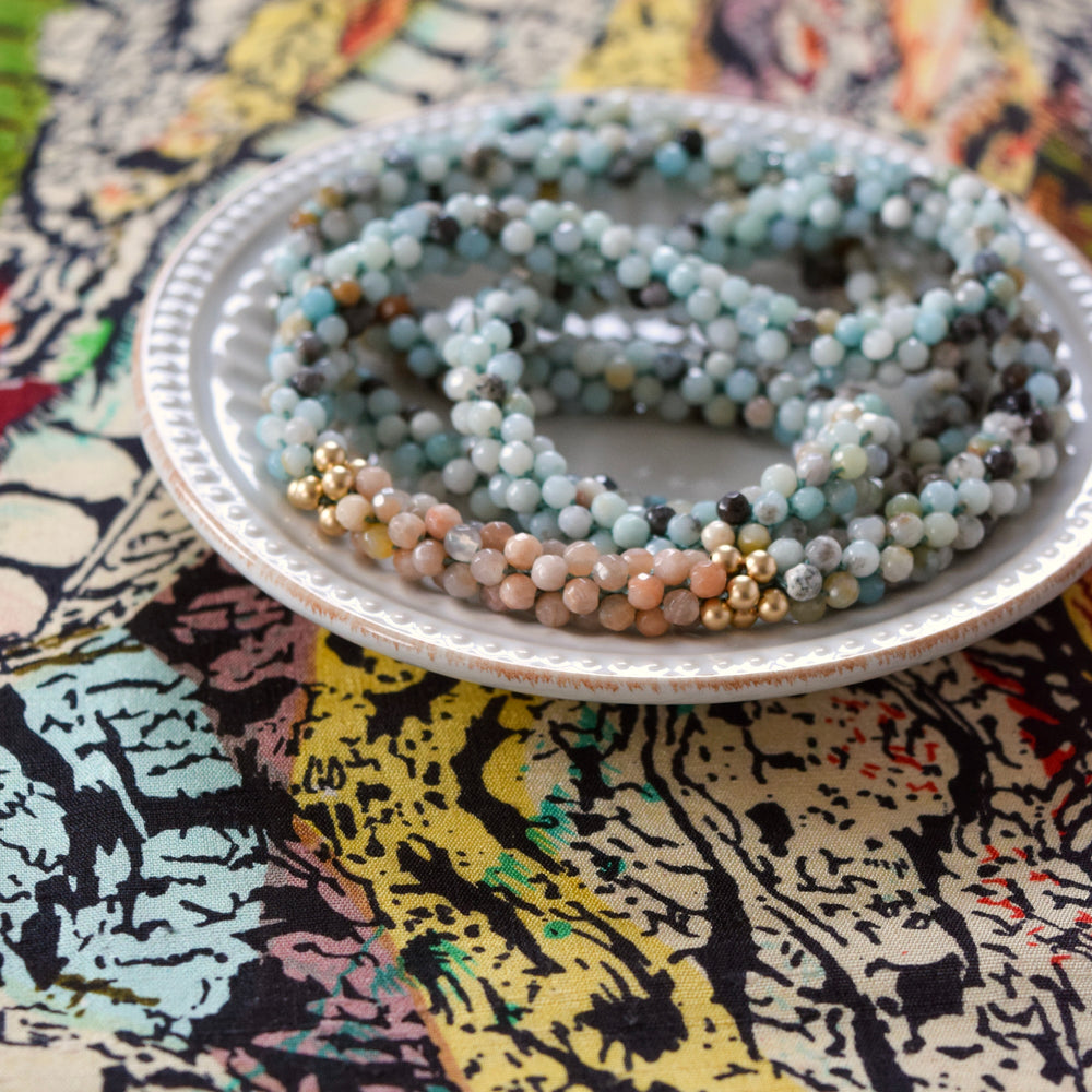 
            
                Load image into Gallery viewer, close up of amazonite, sunstone and gold beaded necklace on colorful background
            
        