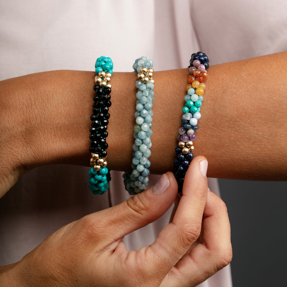 
            
                Load image into Gallery viewer, turquoise, black onyx and gold beaded bracelet on model worn with two other gemstone bracelets
            
        